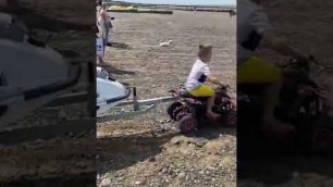 'Electric quad pulling jet ski to the water by kid'