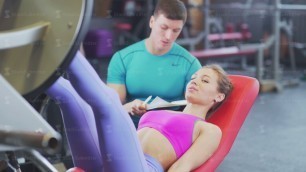 'Sports young woman in the gym with a personal fitness trainer'